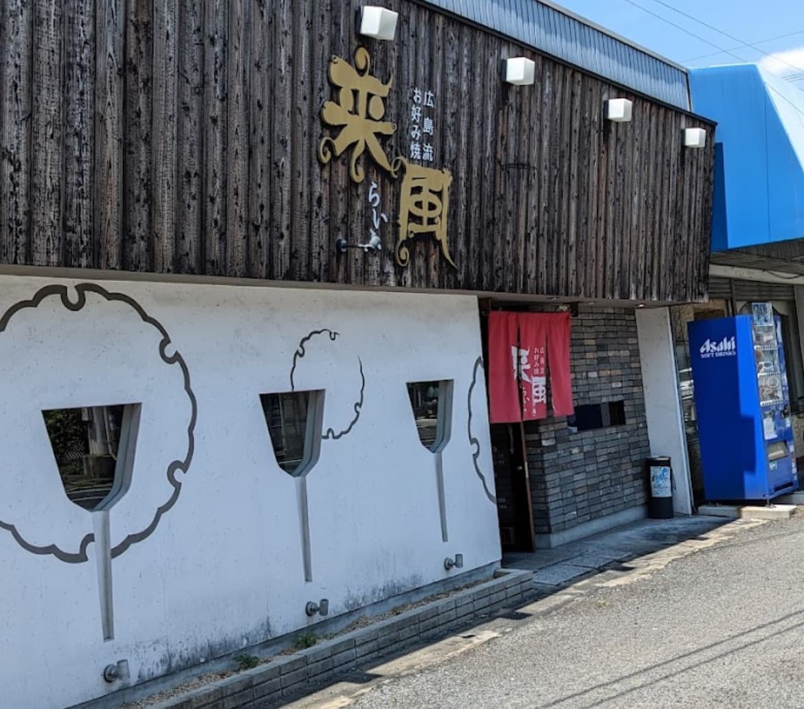 広島流お好み焼 来風の木目外壁と暖簾が見える店舗外観